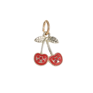 Macro shot of a red cherry charm with sparkling rhinestones and gold-plated details