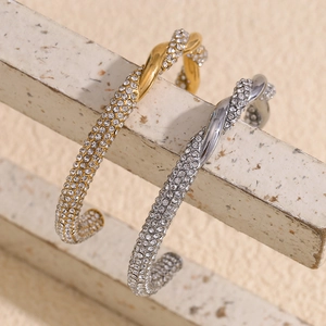 Gedrehtes Edelstahl-Armreif mit 18K Goldbeschichtung und glitzernden Strasssteinen