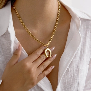 Classic gold horseshoe necklace with shimmering rhinestones on a chunky cuban link chain