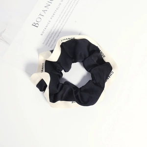 Minimalist black scrunchie with white 'CHANGE' letter print trim for hair styling