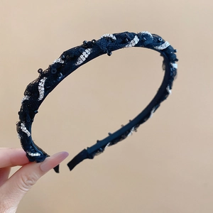 Detail of elegant black lace headband with silver rhinestones and delicate beadwork