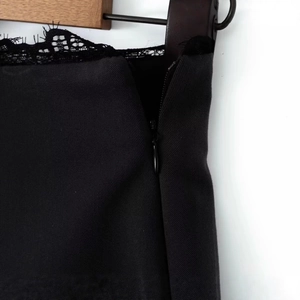 Gros plan sur la bordure en dentelle noire et la fermeture éclair invisible d'une jupe