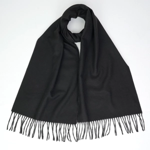 Close-up of soft black cashmere-like scarf texture with elegant fringe detail