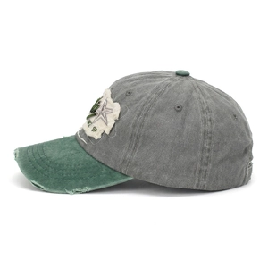 Detail of vintage washed baseball cap featuring distressed brim and contrast star patch