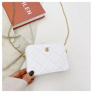 Detail view of white quilted PVC jelly bag with gold chain and floral accent