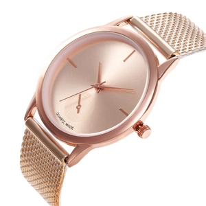 Detailed close-up of rose gold quartz watch with minimalist dial and mesh steel strap