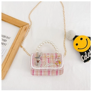 Detail of pink tweed girl's handbag with lace trim, pearl handle and plush bunny doll