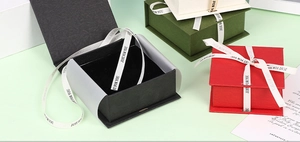 Detailed view of flip-top jewelry gift boxes in various colors with elegant ribbon tie