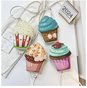 Flat lay of four cupcake-shaped crossbody bags in pastel colors with cute dessert details