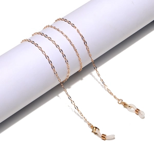 Detail of gold metal glasses chain with adjustable white rubber loops on white display