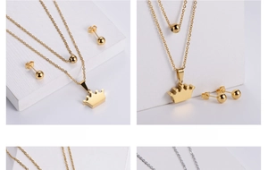 Close-up of gold titanium steel jewelry set with crown pendant and round stud earrings