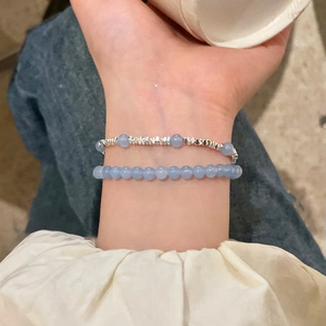 Vue rapprochée de bracelets superposés en aigue-marine et perles d'argent au poignet
