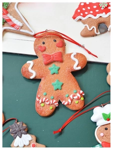 Macro view of gingerbread man Christmas ornaments with red bow and white wavy details
