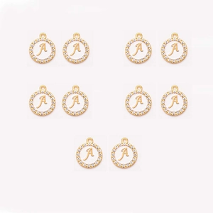 Macro shot of 10 gold alloy round pendants with rhinestone letter A and glossy enamel finish