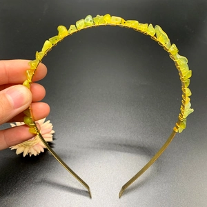 Detailed close-up of handmade golden crown headband with raw yellowish-green crystals