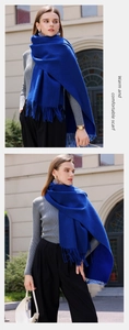 Outdoor lifestyle shot of a soft blue cashmere-feel scarf with elegant fringe detail