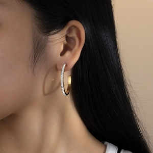 Elegant gold-plated C-shaped hoop earrings with sparkling white zircons on model
