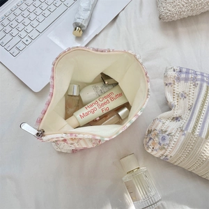 Flat lay of floral quilted makeup bags with skincare products on a desk