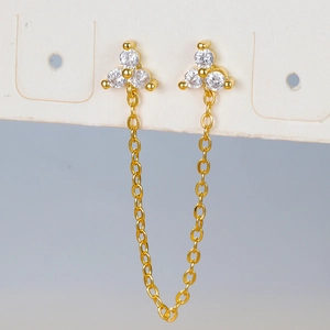 Macro detail of gold chain earrings with sparkling clear cubic zirconia flower studs