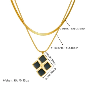 Golden double layer chain necklace with black square pendant on white background