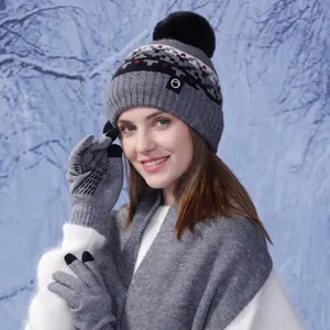 Three-piece winter knitted set with grey pom-pom hat, touchscreen gloves, and shawl