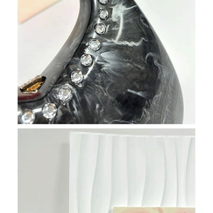 Macro detail of black marble textured acrylic bag with embedded sparkling rhinestones