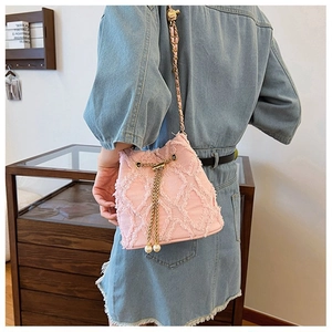 Pink textured bucket bag detail with gold chain strap and pearl fringe decoration