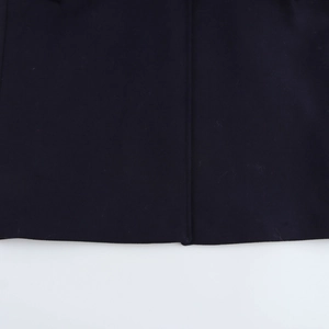 Close-up of the dark blue wool blend overcoat hem showing fabric texture and fine stitching