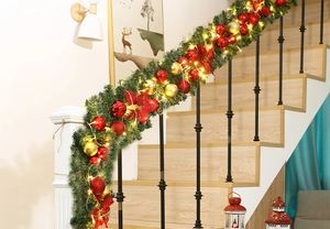 Close-up of 2.7m Christmas garland with red gold balls and warm LED lights on a staircase