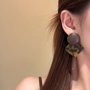 Boucles d'oreilles rétro en bois rond et résine écaille sur mannequin avec fond chaud