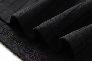 Primer plano del tejido de punto acanalado negro con costuras de acabado profesionales