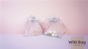 Close-up of grey mesh drawstring jewelry bags with sparkly sequin bow details