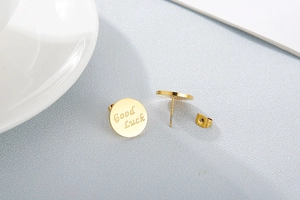 Close-up of gold layered chain necklace featuring the engraved Good Luck pendant