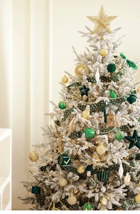Detail of dark green velvet Christmas balls and golden ornaments on a flocked tree