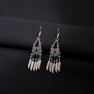 Detail of bohemian drop earrings with blue stones, colorful beads, and silver feathers
