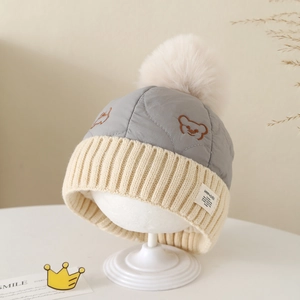 Bonnet tricoté hiver bébé avec écussons ours et pompon en fausse fourrure beige
