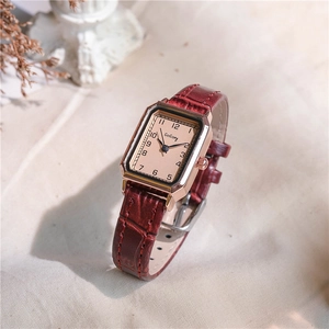 Detail of vintage square watch with rose gold case and embossed red-brown leather strap