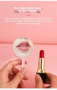 Pink portable handheld mirror showing clear lip reflection with lipstick next to it