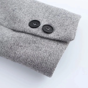 Detailed close-up of grey wool coat cuff featuring premium black resin buttons