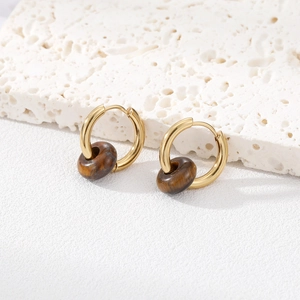 Detailed close-up of gold huggie earrings featuring natural tiger eye stone beads