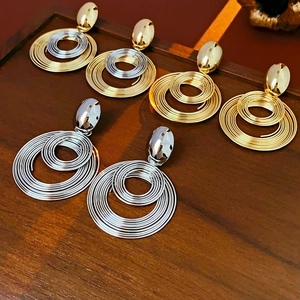 Macro detail of multilayer spiral round earrings in gold, silver and mixed tones