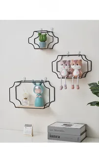 Three-piece set of black metal wave-shaped wall shelves with natural wood bases in a home setting