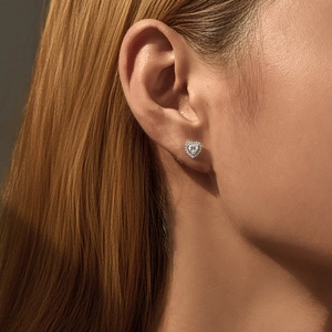 Elegant D-color moissanite heart stud earrings in S925 silver on a model's ear
