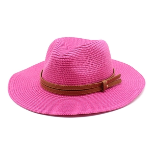 Détail du tissage du chapeau de paille rose avec bande en cuir brun et rivets