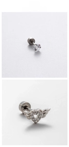 Detailed close-up of heart-shaped titanium steel studs with zircon stones and wings