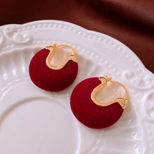 Détail de boucles d'oreilles créoles en velours rouge plaqué or 14 carats sur plat