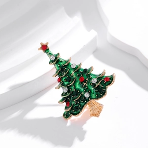 Elegant Christmas tree brooch with green enamel and gold plating on a white geometric stand