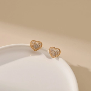 Detailed close-up of 18K gold plated heart stud earrings with cubic zirconia pavé