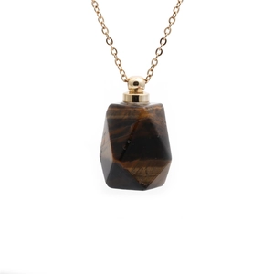 Detailed view of tiger eye stone perfume bottle pendant with golden chain hardware