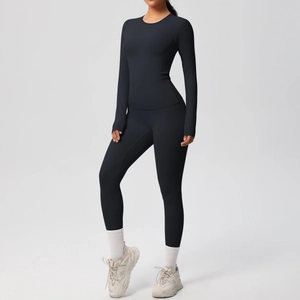Dettaglio del top da yoga a maniche lunghe con fori per i pollici e leggings neri attillati